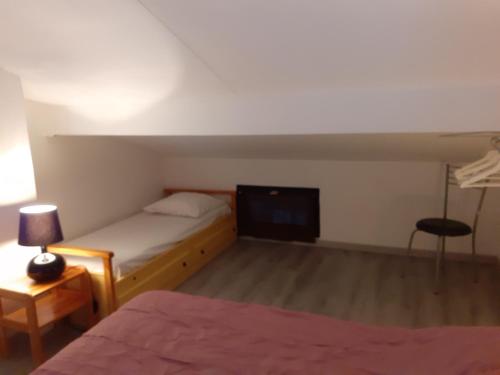 a small bedroom with a bed and a tv at Appartement Santocha in Capbreton
