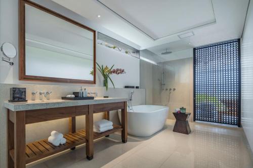 The Residence Bintan في Kawal: حمام مع حوض ومغسلة وحوض استحمام