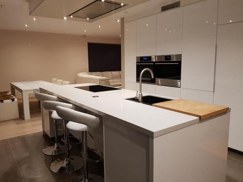 a kitchen with a sink and a counter with bar stools at La Pauline in Veurne