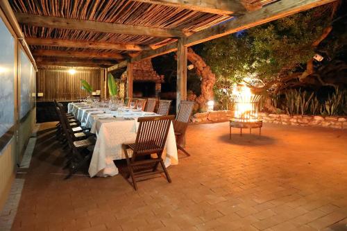 a dining room with a long table and chairs at Blue Bay Lodge in Saldanha