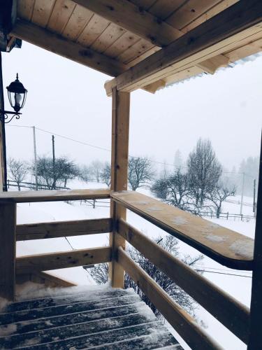 a snow covered porch with a view of a field at Khatky Na Penkakh in Vorokhta