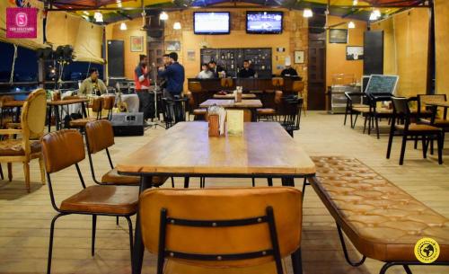 a restaurant with a wooden table and chairs at Pride Premier Solitaire in Dehradun