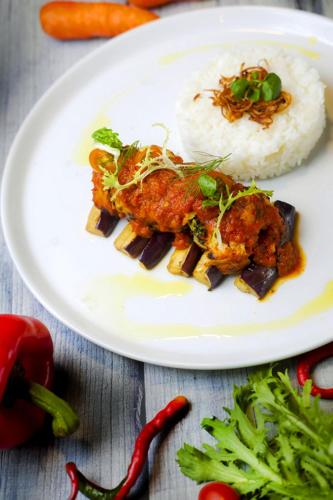 a plate of food with rice and chicken and vegetables at Raintree Boutique Villa & Gallery in Yogyakarta