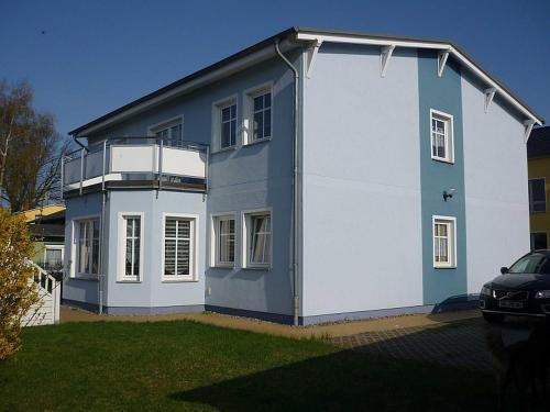 een blauw-wit huis met een balkon bij Uns Huesung in Ahlbeck