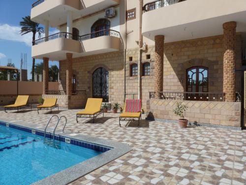 a house with a swimming pool next to a building at DREAM ISLAND Hotel in Luxor