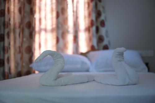two towel swans sitting on top of a bed at Villa Anandha in Trivandrum