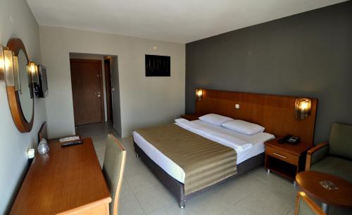 a hotel room with a bed and a chair at Surtel Hotel in Kusadası