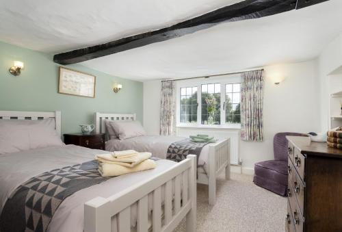 a bedroom with two beds and a desk and a window at Riverside House in Broom