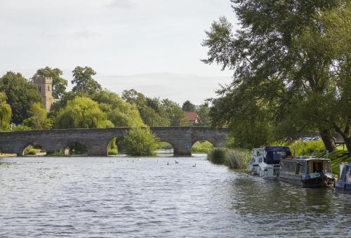 a river with two boats and ducks in the water at Riverside House in Broom
