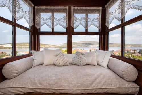 a white couch in a room with windows at Alacati Kapari Hotel - Special Category in Alacati