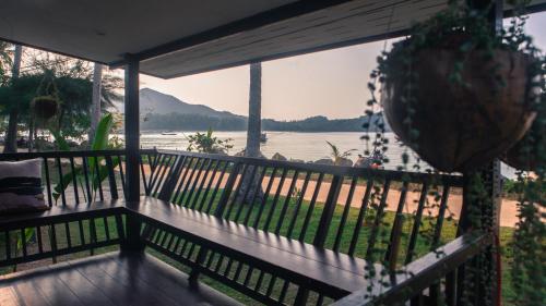 einen Balkon mit Blick auf das Wasser in der Unterkunft Blue Moon Beach Hut in Ko Phangan