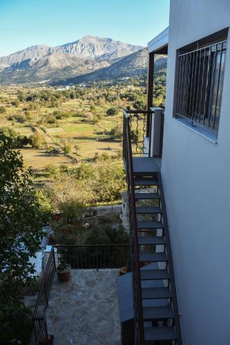 a staircase leading to a balcony with mountains in the background at Athivoli Elegant Apartments in Káto Metókhion
