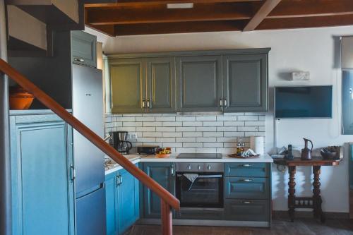 a kitchen with blue cabinets and a stove at Athivoli Elegant Apartments in Káto Metókhion