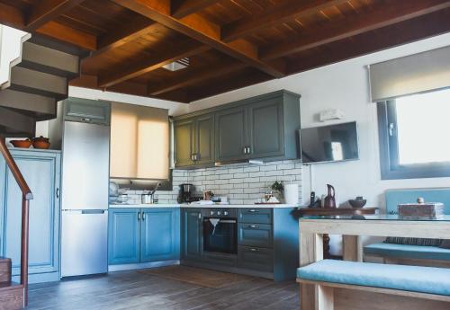 eine Küche mit blauen Schränken und einer Treppe in der Unterkunft Athivoli Elegant Apartments in Káto Metókhion