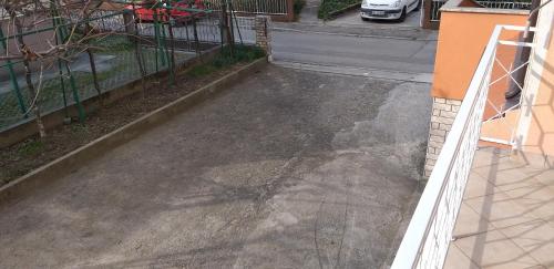 an empty parking lot with a fence and a driveway at Love 2 Solkan in Nova Gorica