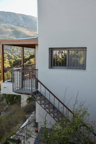 a white house with a staircase and windows at Athivoli Elegant Apartments in Káto Metókhion