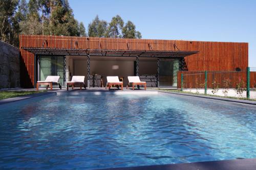 a swimming pool with two chairs at Dantas Village in Moure