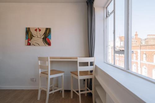 een bureau en stoel in een kamer met een raam bij Modern Studio Flat. Central London. Zone 1. in Londen