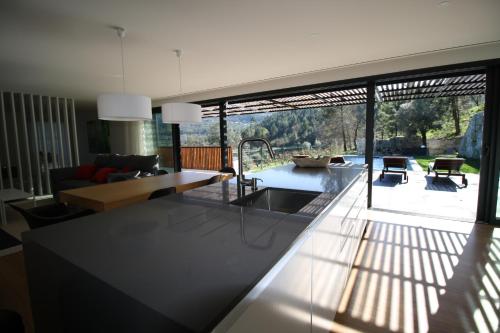 a kitchen and living room with a view of a patio at Dantas Village in Moure