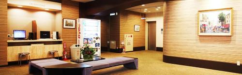 a lobby with a couch and a tv in it at Takamatsu City Hotel in Takamatsu