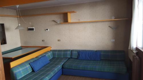 un soggiorno con divano blu e cuscini blu di appartamento con vista Cervino- frazione Breuil Cervinia Cieloalto Piano 3 appartamento 306 reception Coin au Paradise a Breuil-Cervinia