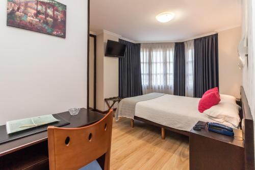 a hotel room with a bed and a desk at Hotel Gijon in Gijón