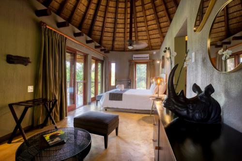 a room with a bedroom with a bed and a mirror at Emhosheni River Lodge in Balule Game Reserve