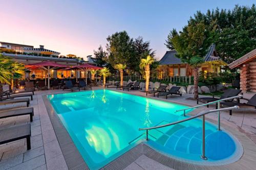 a large swimming pool in a resort with chairs at Maisonette am Belchen in Bad Krozingen