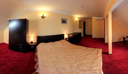 a bedroom with a large bed and two night stands at La Storia Guest House in Piteşti