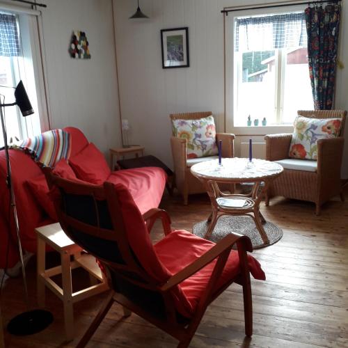Una sala de estar con un sofá, una mesa y sillas. en Stuga Lugnvik, en Lugnvik