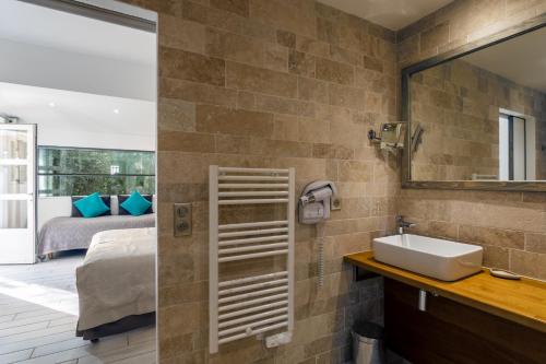 a bathroom with a sink and a mirror and a bed at Le Mas de Cocagne in Saintes-Maries-de-la-Mer