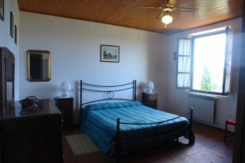 a bedroom with a bed and a ceiling fan at Ginestra in Poggibonsi