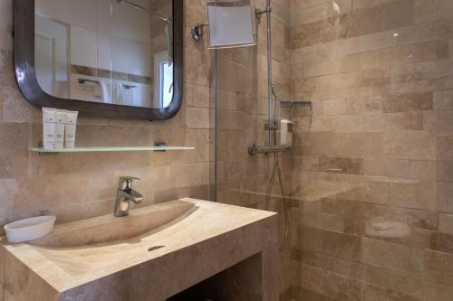 a bathroom with a sink and a shower at Le Mas de Cocagne in Saintes-Maries-de-la-Mer