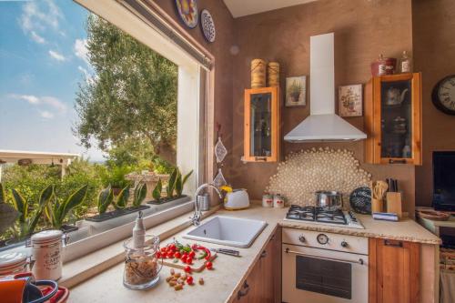 een keuken met een spoelbak en een raam bij TD Casa Torchiano Hilltop Pool with Sea View in Monopoli