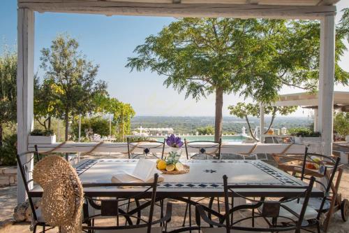 een tafel en stoelen op een terras met uitzicht bij TD Casa Torchiano Hilltop Pool with Sea View in Monopoli