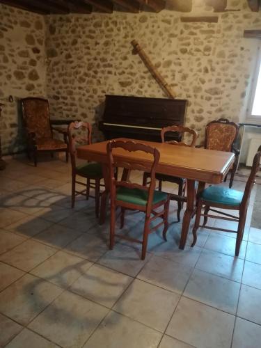 une salle à manger avec une table et un piano dans l'établissement La campagne vallée de Chevreuse à 35 KM de Paris, à Fontenay-lès-Briis