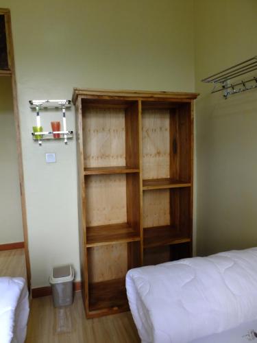 a room with a book shelf next to a bed at Enjivai Hostel in Arusha