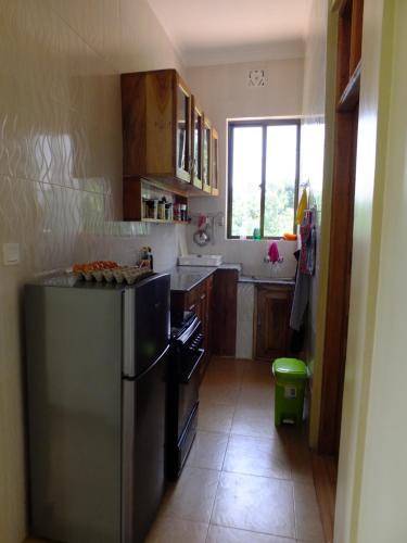 a kitchen with a stainless steel refrigerator and a window at Enjivai Hostel in Arusha