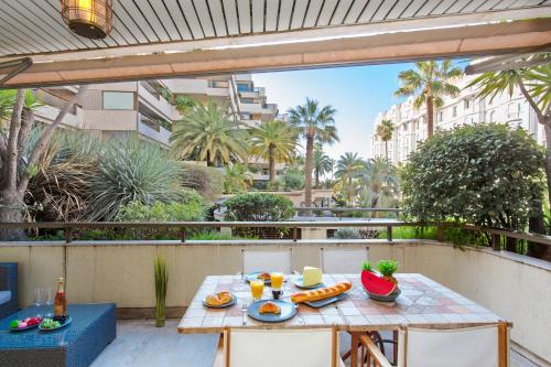 - une table sur un balcon avec de la nourriture dans l'établissement Gray d'Albion YourHostHelper, à Cannes