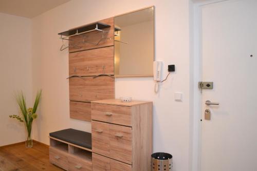 a bathroom with a wooden dresser and a mirror at Ferienwohnung mit Seeblick, Unterach am Attersse in Unterach am Attersee