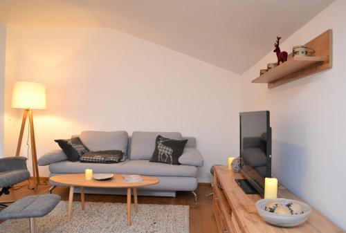 a living room with a couch and a table at Ferienwohnung mit Seeblick, Unterach am Attersse in Unterach am Attersee