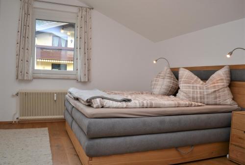um sofá com almofadas na sala de estar em Ferienwohnung mit Seeblick, Unterach am Attersse em Unterach am Attersee