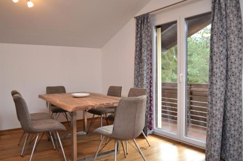 una sala da pranzo con tavolo, sedie e finestra di Ferienwohnung mit Seeblick, Unterach am Attersse a Unterach am Attersee