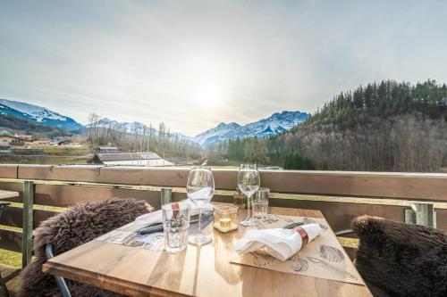 a wooden table with wine glasses on a balcony at Gasthof Bären in Hasliberg