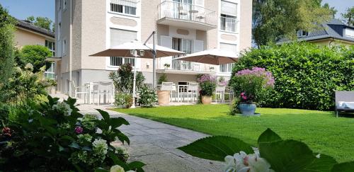 a apartment building with an umbrella and a lawn at The Little Guesthouse in Salzburg