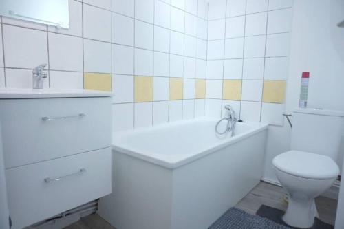 biała łazienka z wanną i toaletą w obiekcie Studio Cosy 2 Proche gare w mieście Saint-Quentin