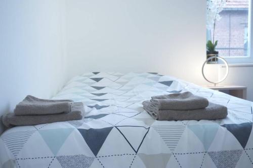 sypialnia z łóżkiem z ręcznikami w obiekcie Studio Cosy 2 Proche gare w mieście Saint-Quentin