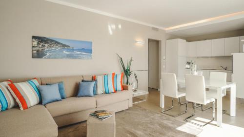 a living room with a couch and a dining room at Residence San Marco Suites&Apartments Alassio in Alassio