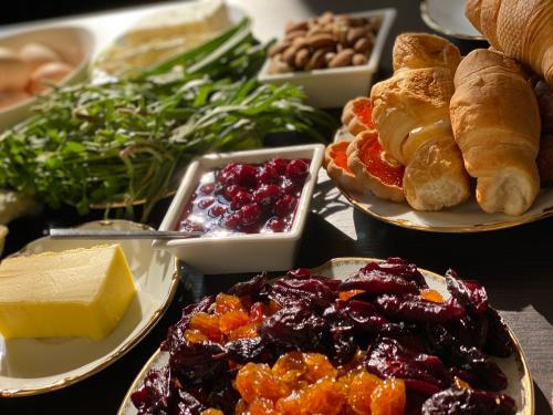 a table topped with plates of food with bread and pastries at Zanger Hotel in Goris