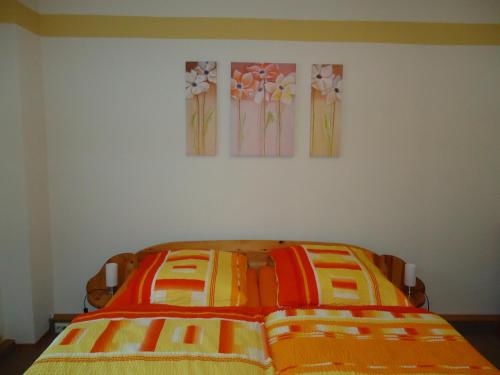 two beds in a bedroom with two paintings on the wall at Pension Thaler Hof in Thale